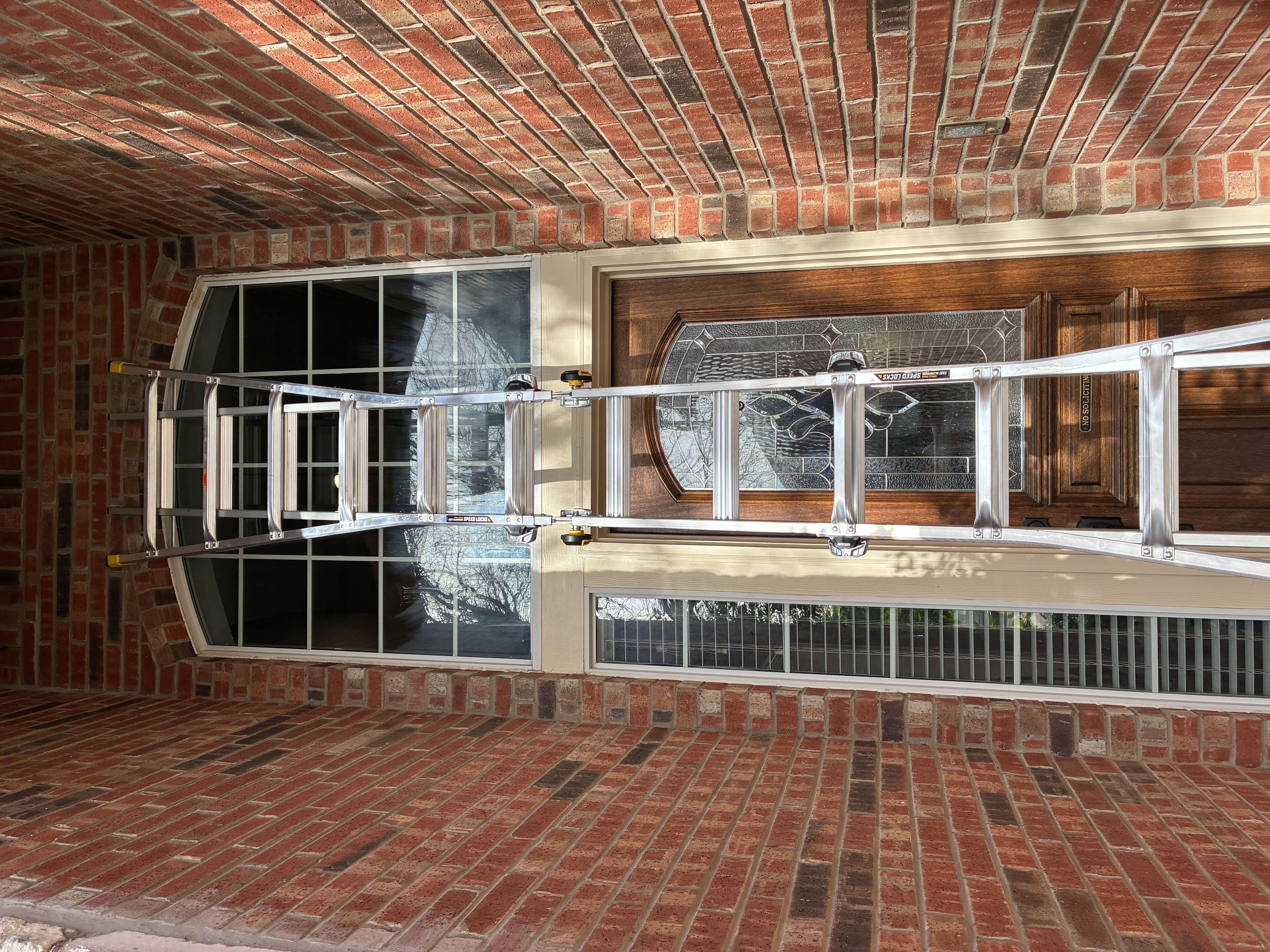 Two-story entryway window cleaning with ladder in McKinney, TX