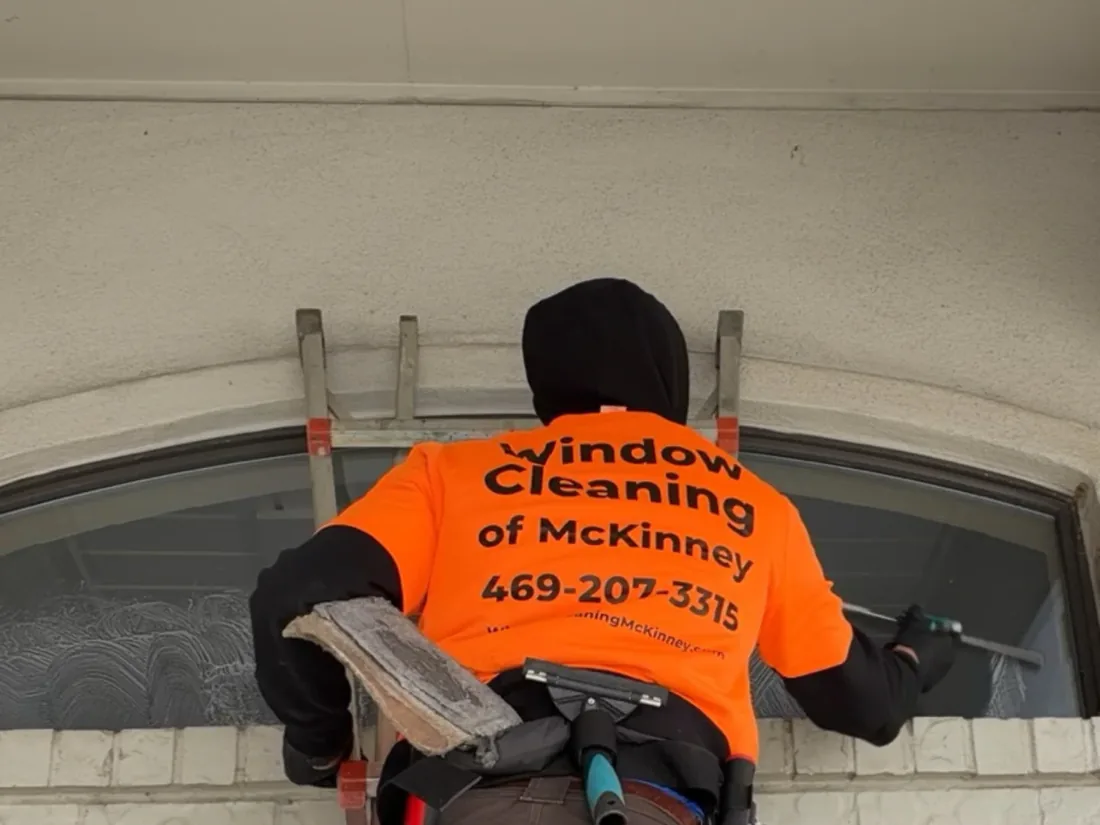 Arched window cleaning from ladder in McKinney, TX